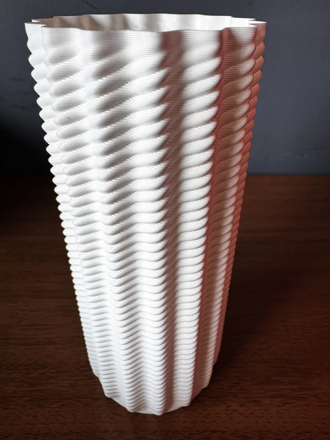 Vaso impresso em PETG branco, visto de baixo, mostrando a torção das camadas